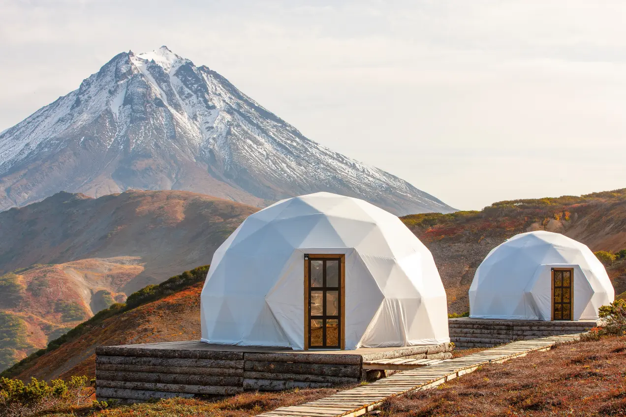Купольные дома на фоне вулкана